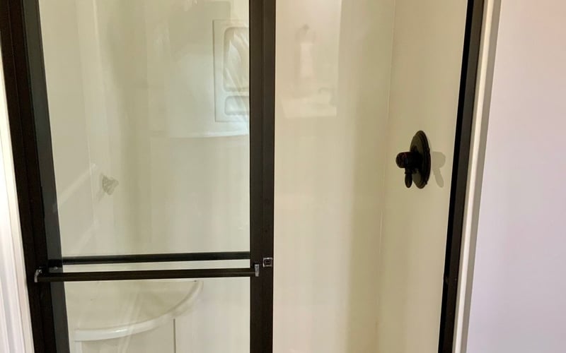 Walk-in shower with black frame glass door