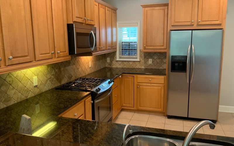 Kitchen with maple cabinets, granite counters, gas range, and stainless fridge