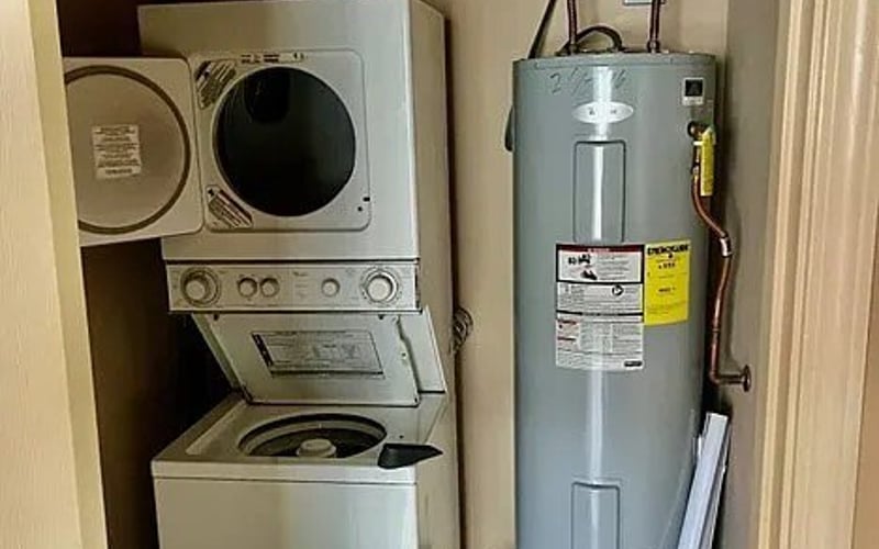 Stacked washer/dryer and water heater in utility closet