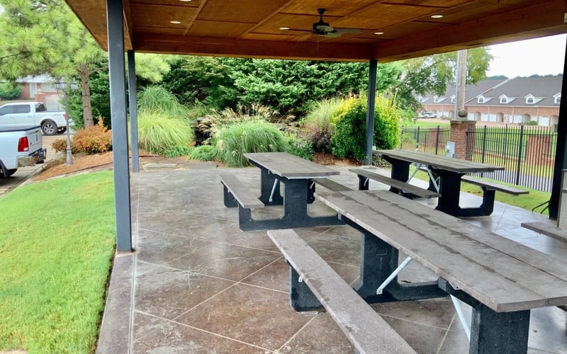 Covered outdoor pavilion with picnic tables and landscaping