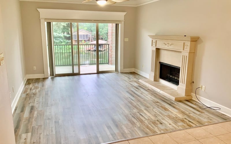 Living room with hardwood floors, fireplace, and sliding glass doors to balcony