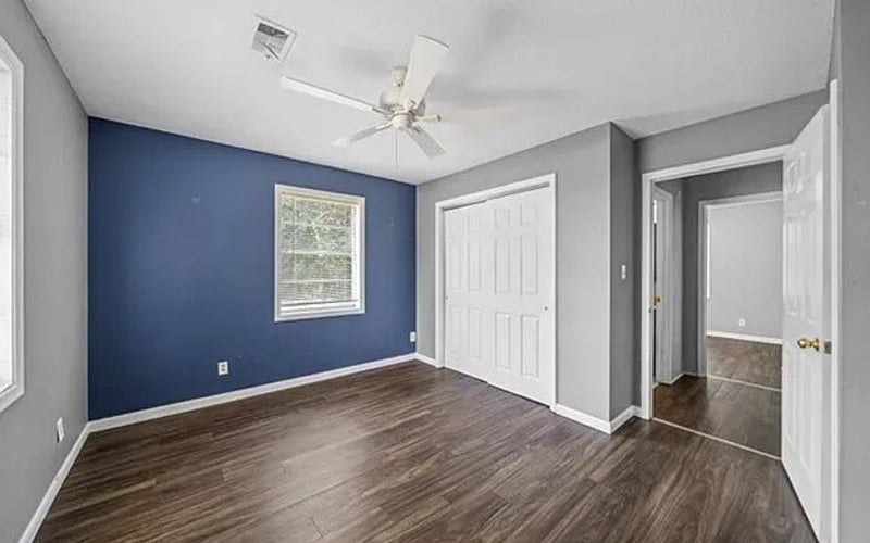 Bedroom with navy blue accent wall and closet