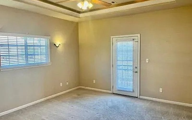 Bedroom with tray ceiling and door to balcony