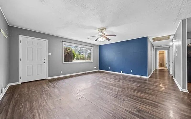 Living room with blue front door and open floor plan