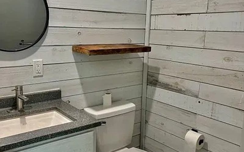 Bathroom with blue-grey vanity and shiplap walls