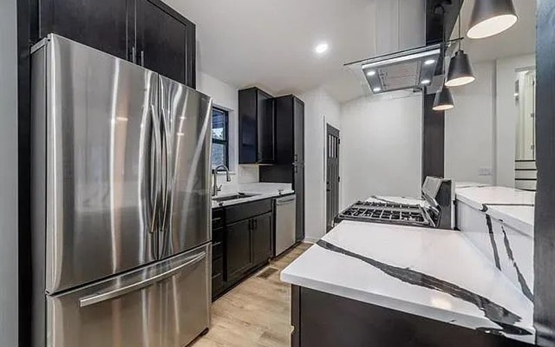 Kitchen with dark cabinets and marble island