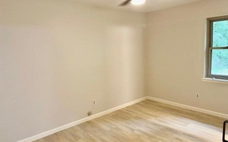 Bedroom with ceiling fan and corner window