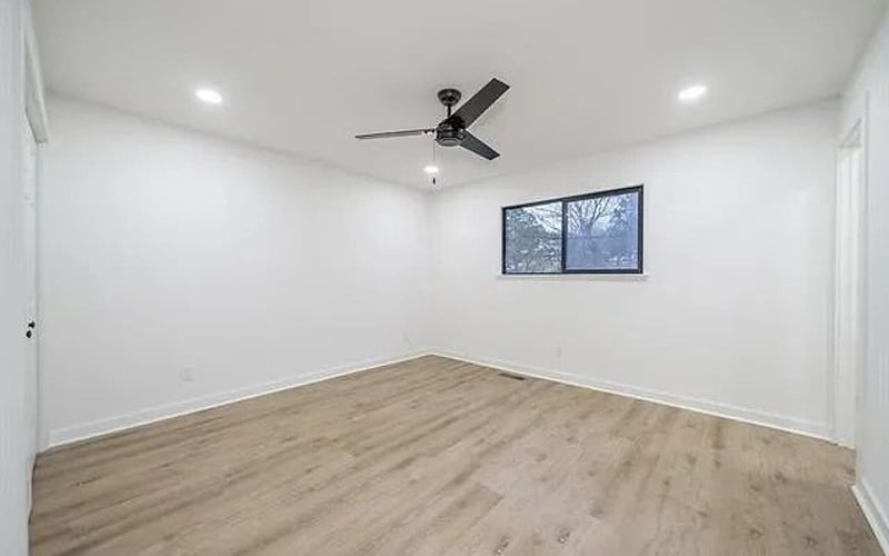 Second bedroom with ceiling fan and hardwood floors