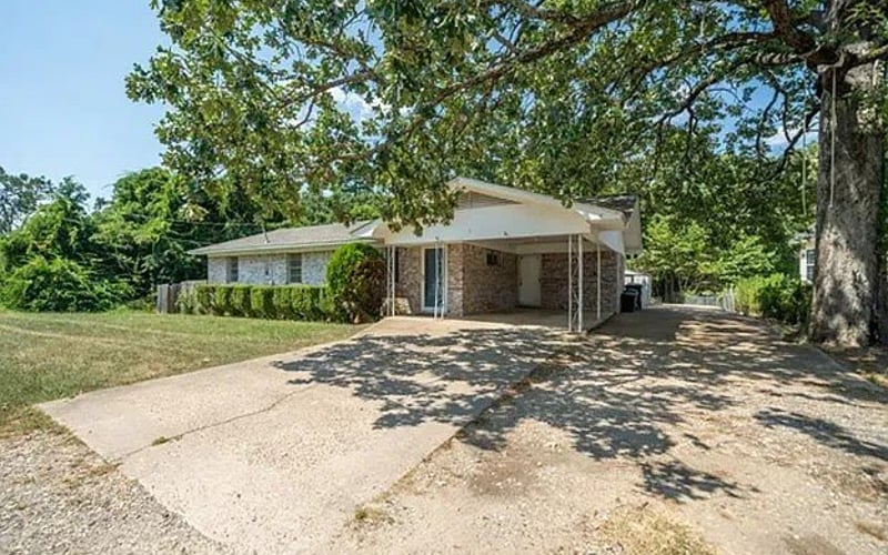 Front exterior with carport and mature oak tree