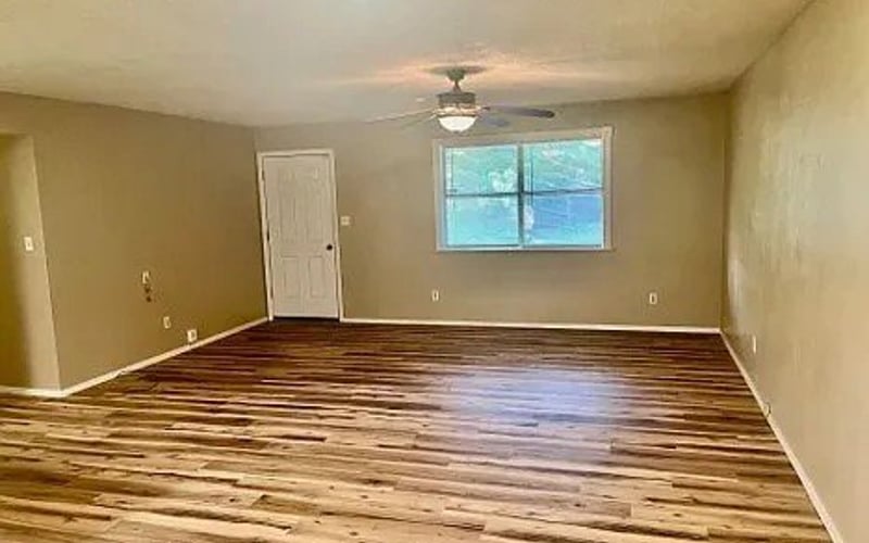 Open living area with hardwood floors and ceiling fan