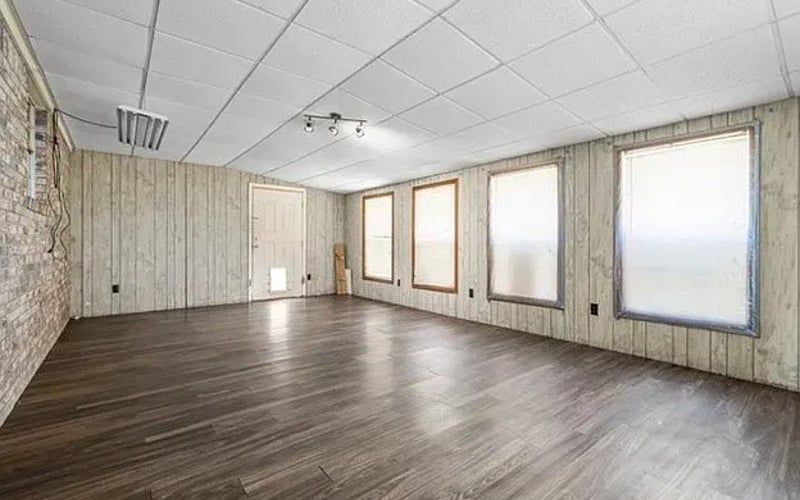 Open room with wood-paneled walls and hardwood floors