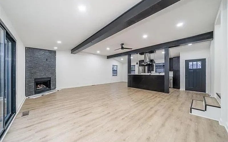 Open living area with fireplace and exposed beams