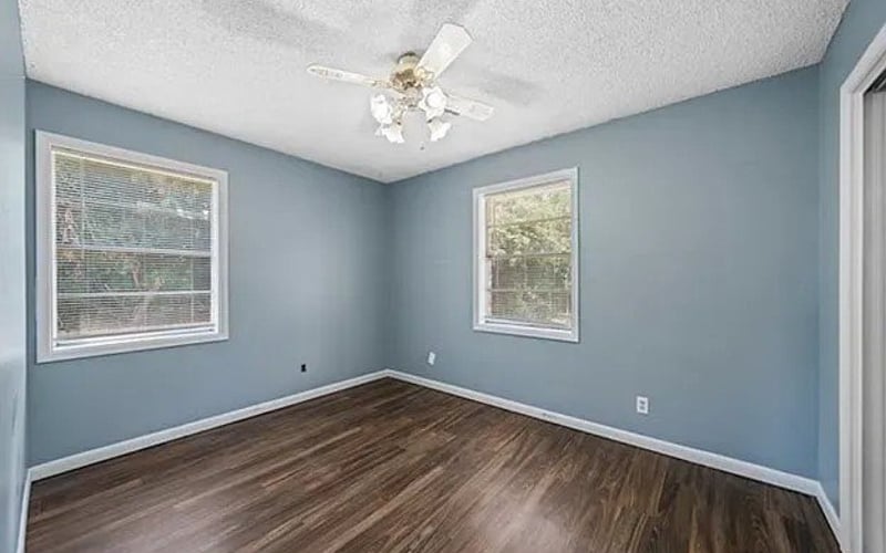 Bedroom with blue walls, ceiling fan and hardwood floors