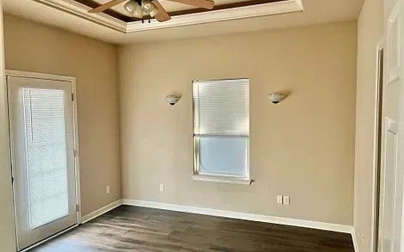 Master bedroom with tray ceiling and balcony door