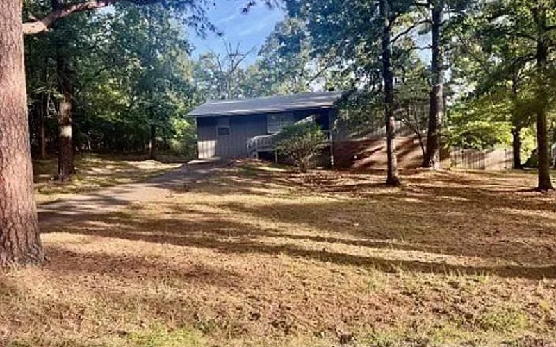 Front exterior with driveway and trees