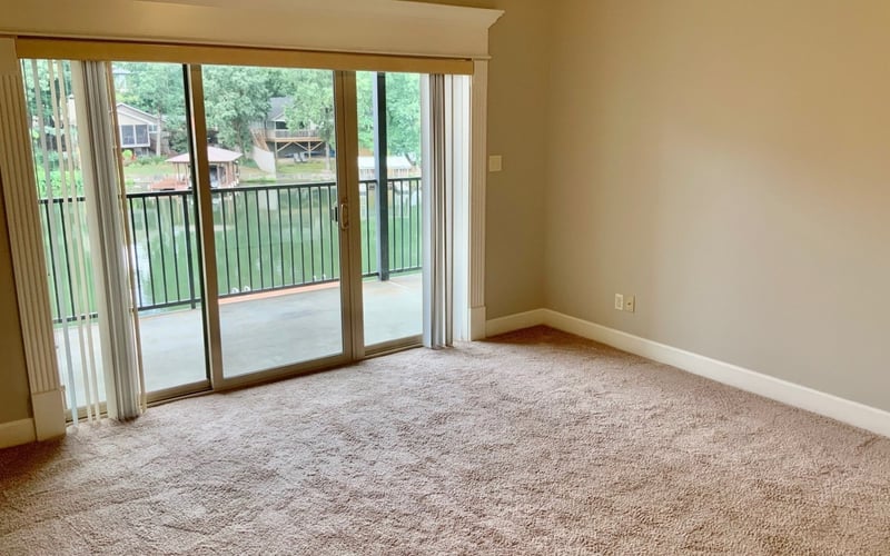 Living area with sliding glass doors opening to balcony with lake view