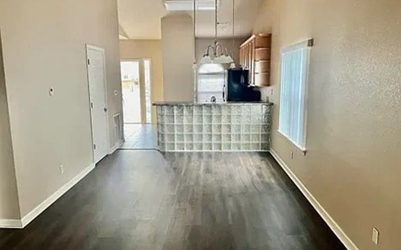 Open living area with dark hardwood floors and kitchen bar