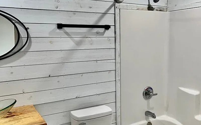 Bathroom with tub and shiplap walls