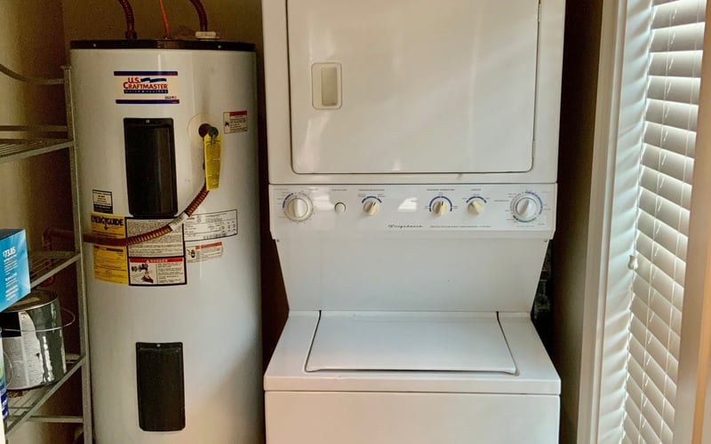 Stacked washer/dryer and water heater in laundry closet