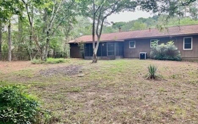 Rear exterior with wooded backyard