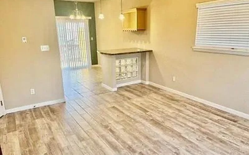 Open dining area with kitchen bar beyond