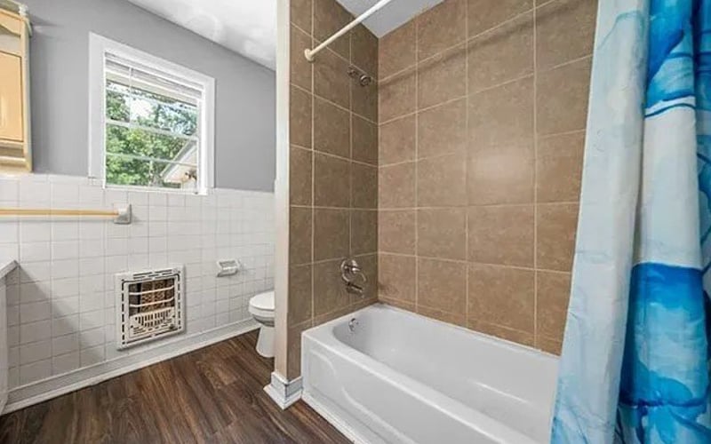 Bathroom with tub, tile surround and window