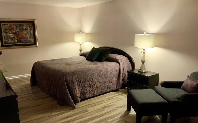 Master bedroom with dark headboard and reading chair