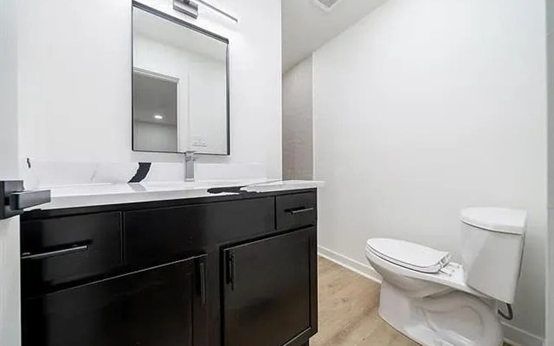 Bathroom with dark vanity and white countertop
