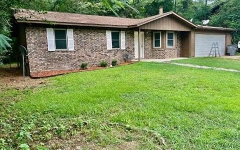 Front exterior with brick and attached garage