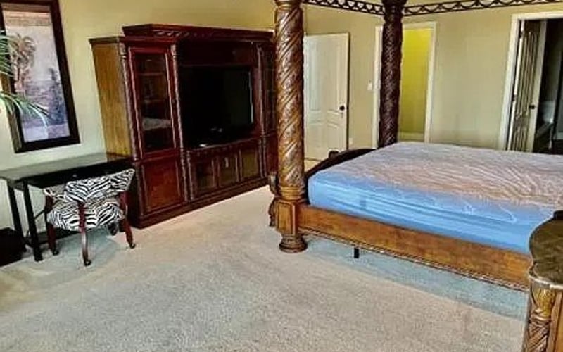 Master bedroom with four-poster bed and TV