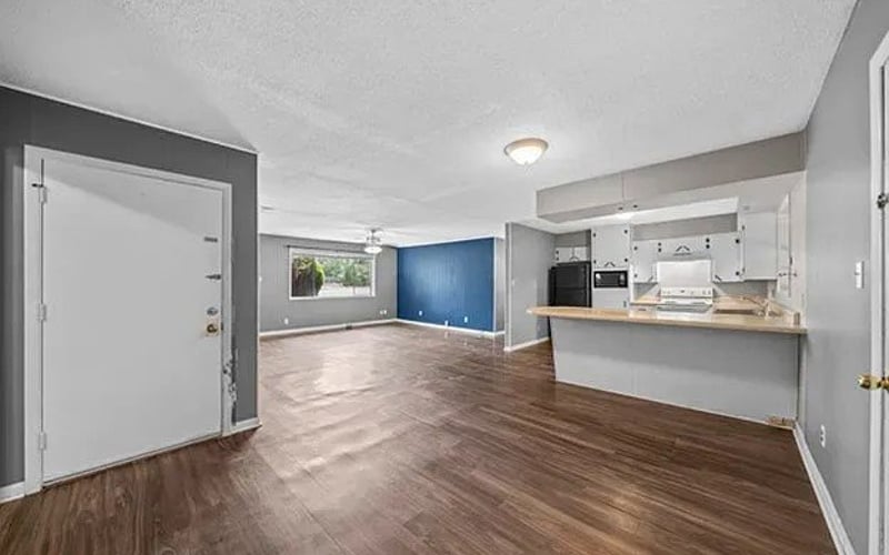 Open living area with blue accent wall and kitchen peninsula