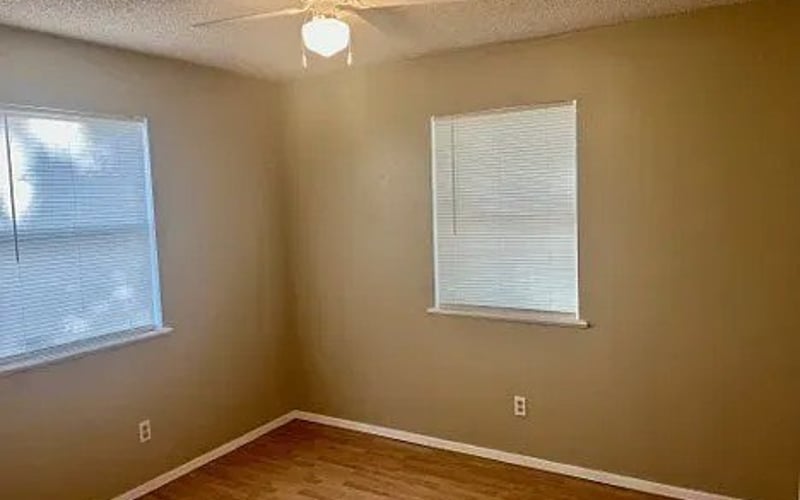 Bedroom with two windows and ceiling fan