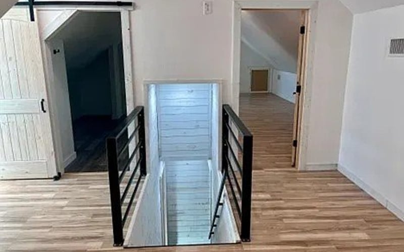 Upstairs landing with barn door and glass floor panel