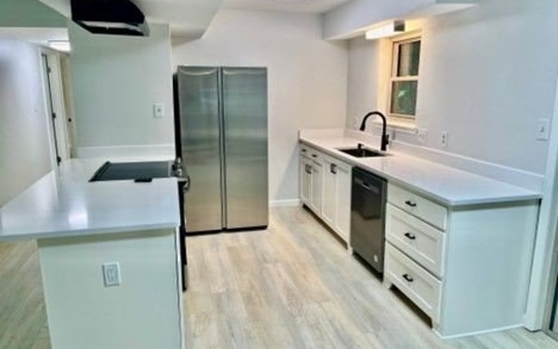 Kitchen with stainless refrigerator and white cabinets