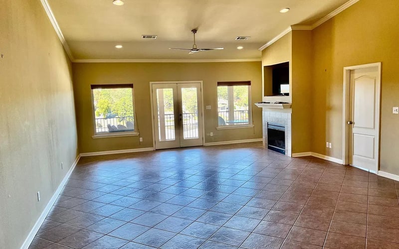 Large living room with fireplace and French doors to balcony