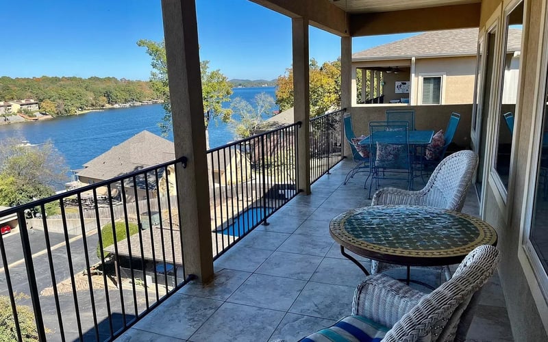 Covered balcony with lake view and wicker seating