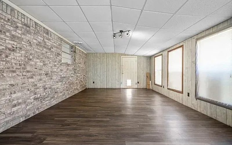 Large room with brick accent wall and hardwood floors