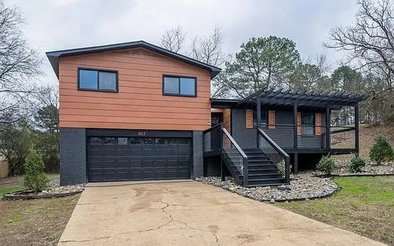 Front exterior with cedar siding, garage, and pergola deck