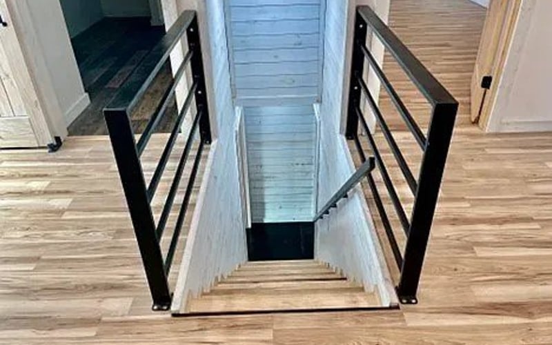 Staircase with black metal railing looking down