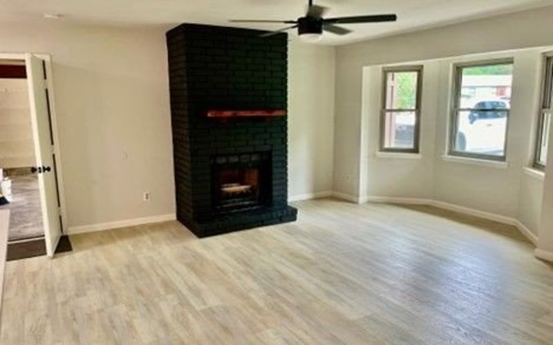 Living room with brick fireplace and ceiling fan